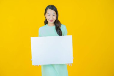 Renkli arka planda boş beyaz ilan panosu olan güzel Asyalı kadın portresi