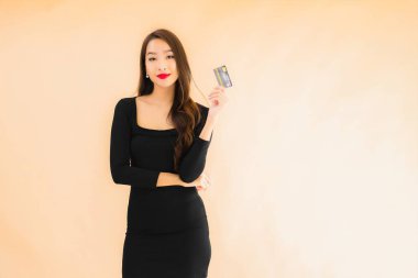 Renkli arka planda alışveriş yapmak için kredi kartı olan güzel bir Asyalı kadın portresi.