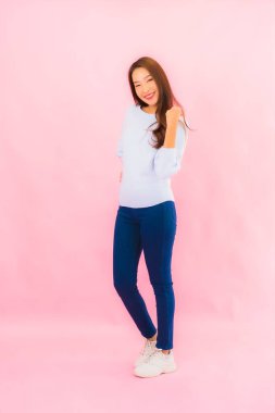 Portrait beautiful young asian woman smile with action on pink isolated background