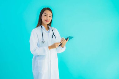 Steteskoplu ve akıllı tabletli güzel Asyalı doktor kadının portresi mavi arka planda hastane ve klinikte kullanılacak.