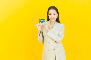 Güzel bir Asyalı kadının portresi. Renkli kredi kartıyla gülüyor.