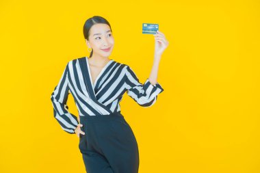 Güzel bir Asyalı kadının portresi. Renkli kredi kartıyla gülüyor.