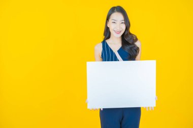 Renkli arka planda boş beyaz ilan panosu olan güzel Asyalı kadın portresi
