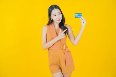 Güzel bir Asyalı kadının portresi. Renkli kredi kartıyla gülüyor.