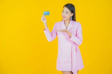 Güzel bir Asyalı kadının portresi. Renkli kredi kartıyla gülüyor.