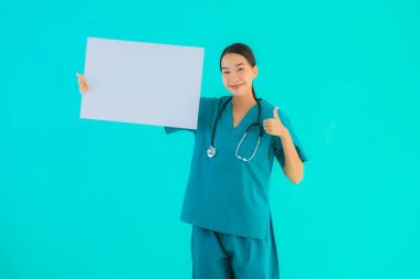 Fotokopi için boş kâğıt tahtası olan güzel Asyalı genç doktor kadın hastane ve klinikteki sağlık hizmetleri konseptinde mavi izole edilmiş arka plan.