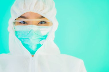 Güzel, genç Asyalı doktor kadın portre. Koronavirüsten ya da mavi arka planda kovid19 'dan korunmak için ppe ya da kişisel koruyucu ekipman takıyor.