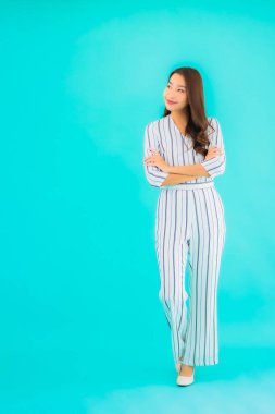 Asyalı güzel bir kadının portresi mavi izole edilmiş arka planda gülümsüyor.