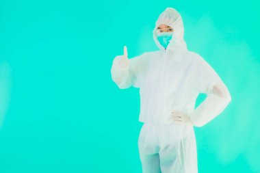 Güzel, genç Asyalı doktor kadın portre. Koronavirüsten ya da mavi arka planda kovid19 'dan korunmak için ppe ya da kişisel koruyucu ekipman takıyor.