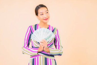 Parası, parası ve cep telefonu olan güzel Asyalı bir kadının portresi.