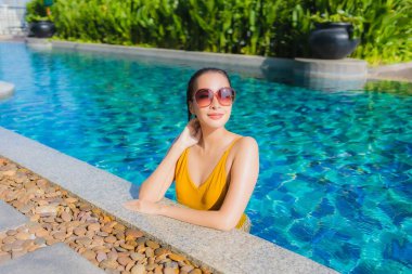 Güzel bir Asyalı kadın portresi. Rahatlayın. Keyifli bir tatil için oteldeki yüzme havuzunda mutlu bir gülümseme.