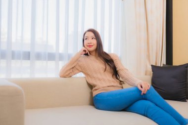 Güzel bir Asyalı kadın portresi rahatla. Gülümse. Yatak odasının iç dekorasyonunda mutlu ol.