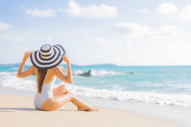 Güzel bir Asyalı kadının portresi. Rahatlayın. Plaj okyanusunda tatil yaparken gülümseyin.