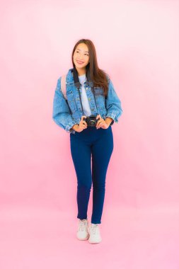 Portrait beautiful young asian woman backpack or luggage with camera ready for travel in vacation on pink background