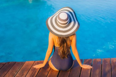 Güzel Asyalı genç bir kadının portresi. Tatilde tatil yapmak için otel havuzunda dinleniyor.