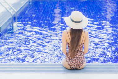 Tatil gezilerinde yüzme havuzunda rahatlayan güzel bir Asyalı kadın portresi.