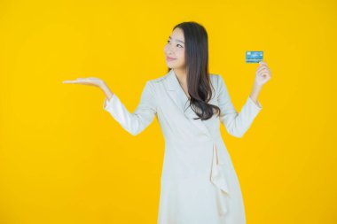 Güzel bir Asyalı kadının portresi. Renkli kredi kartıyla gülüyor.