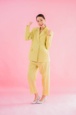 Portre güzel Asyalı genç iş kadını pembe arka planda gülümsüyor