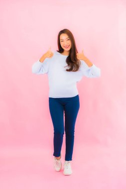 Portrait beautiful young asian woman smile with action on pink isolated background
