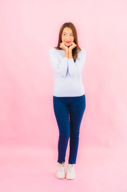 Portrait beautiful young asian woman smile with action on pink isolated background