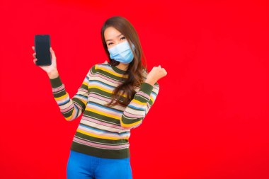 Kovid19 'u korumak için telefon maskeli güzel Asyalı kadın portresi.
