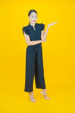 Portre güzel Asyalı kadın gülümsüyor. Renkli arka planda hareket var.