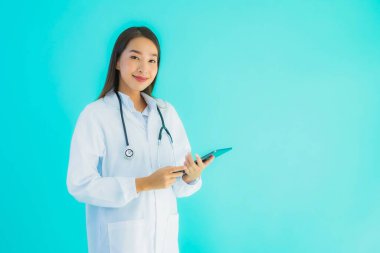 Steteskoplu ve akıllı tabletli güzel Asyalı doktor kadının portresi mavi arka planda hastane ve klinikte kullanılacak.