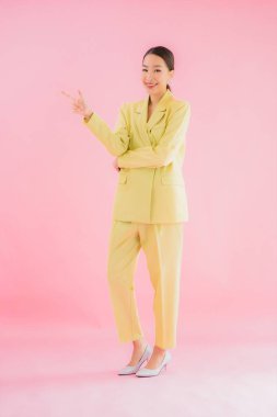 Portre güzel Asyalı genç iş kadını pembe arka planda gülümsüyor