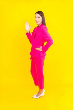 Güzel bir Asyalı kadın sarı arka planda gülümsüyor.