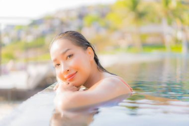 Güzel bir Asyalı kadın portresi. Rahatlayın. Okyanus manzaralı, tatil köyündeki yüzme havuzunda rahatlayın.