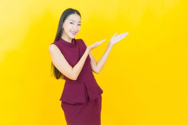 Portre güzel Asyalı kadın gülümsüyor. Renkli arka planda hareket var.