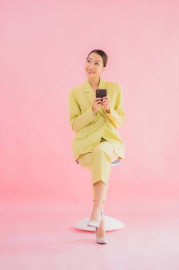 Güzel Asyalı iş kadını portresi. Arka planda kahve fincanı ve akıllı cep telefonu kullanıyor.