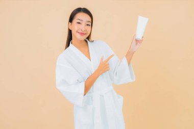 Şişe losyonu ve yüz kremi sürmüş güzel bir Asyalı kadın portresi.