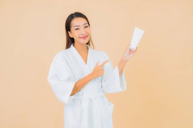 Şişe losyonu ve yüz kremi sürmüş güzel bir Asyalı kadın portresi.