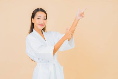 Güzel bir Asyalı kadın portresi. Üzerinde gülücük olan bir bornoz giyiyor.