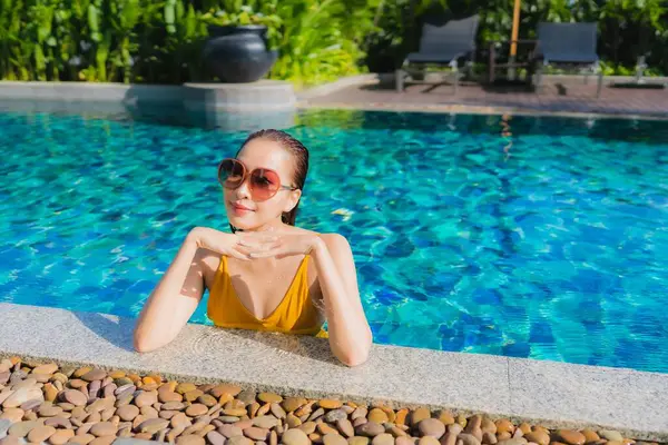 Güzel bir Asyalı kadın portresi. Rahatlayın. Keyifli bir tatil için oteldeki yüzme havuzunda mutlu bir gülümseme.