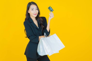 Renkli arka planda akıllı cep telefonuyla güzel Asyalı kadın gülümsemesi