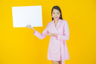 Renkli arka planda boş beyaz ilan panosu olan güzel Asyalı kadın portresi