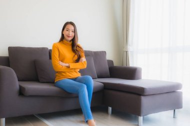 Genç Asyalı kadının portresi mutlu. Rahat ol. Koltukta gülümse.