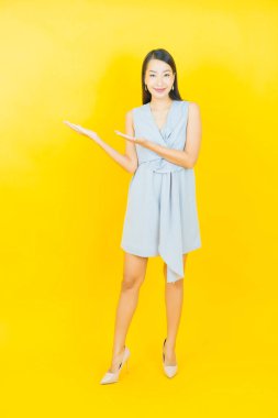 Portre güzel Asyalı kadın gülümsüyor. Renkli arka planda hareket var.