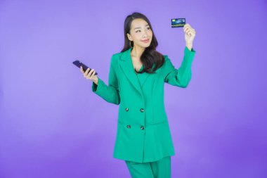 Güzel bir Asyalı kadının portresi. Renkli kredi kartıyla gülüyor.