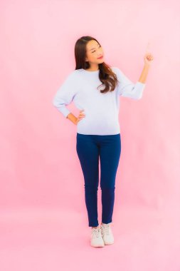 Portrait beautiful young asian woman smile with action on pink isolated background