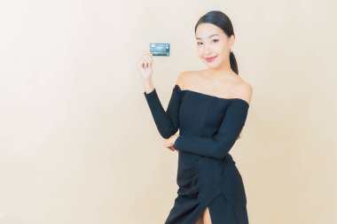 Güzel bir Asyalı kadının portresi. Renkli kredi kartıyla gülüyor.