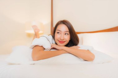 Güzel bir Asyalı kadının portresi. Gülümse. Yatak odasında rahatla.