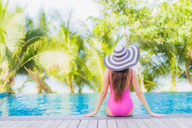 Portre güzel Asyalı kadın gülümsemesi tatil gezisinde tatil otelinde yüzme havuzunda rahatla.