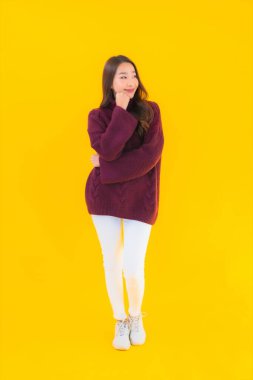 Güzel Asyalı kadın gülümsüyor. Sarı izole edilmiş arka planda başka bir eylemde mutlu.