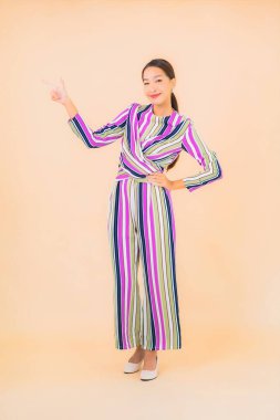 Güzel Asyalı kadın gülümsemesi. Renkli arka planda rahatla.