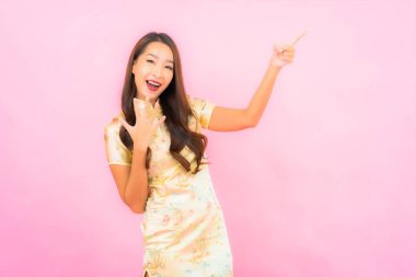 Portre güzel Asyalı genç kadın gülümsüyor Çin 'in yeni yıl konseptiyle pembe arkaplan üzerine