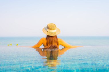 Güzel bir Asyalı kadın portresi. Rahatlayın, gülümseyin. Tatil için oteldeki yüzme havuzunun keyfini çıkarın.