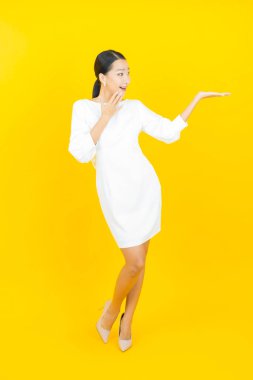 Portre güzel Asyalı kadın gülümsüyor. Renkli arka planda hareket var.